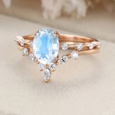 a ring with an oval blue topaz surrounded by small white diamonds and rose petals