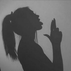 the silhouette of a woman holding her hands up