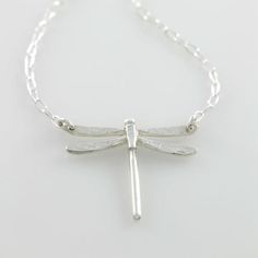 Part of my Spirit Animal collection, this whimsical and pretty little dragonfly pendant will add a bit of charm to any outfit. Handmade in tarnish-resistant sterling silver, each unique pendant is embellished with the texture of a bodhi leaf on each wing. Choose from small and large varieties. Comes on a sterling silver chain that is adjustable between 14 and 17 inches depending on your preference. Pendant is available in small or large. Looks great by itself or styled with your other jewelry an Nature-inspired Sterling Silver Butterfly Jewelry, Dainty Silver Dragonfly Jewelry, Dainty Sterling Silver Dragonfly Jewelry, Handmade Silver Dragonfly Jewelry, Nickel-free Sterling Silver Dragonfly Jewelry, Elegant Sterling Silver Dragonfly Necklace, Elegant Sterling Silver Dragonfly Jewelry, Dragonfly Shaped Sterling Silver Jewelry Gift, Handmade Sterling Silver Dragonfly Jewelry