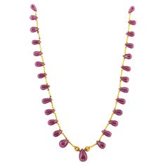 Hand made in the Etruscan style, designed as twenty eight ruby drops of rich deep raspberry colour, with a larger ruby drop in the center, enhanced by high karat gold link beads and tubular links, attached to a high carat gold custom made clasp. 15 ½ in. (39.4 cm.) long. Luxury Briolette Drop Necklace, Ruby Briolette Necklace In Fine Jewelry Style, Fine Jewelry Ruby Briolette Necklace, Ruby Briolette Fine Jewelry Necklace, Fine Jewelry Ruby Necklace In Pear Shape, Formal Ruby Drop Necklace, Ruby Briolette Gemstone Jewelry, Formal Drop Ruby Necklaces, Fine Jewelry Ruby Drop Necklaces