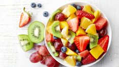 a white bowl filled with sliced fruit on top of a table