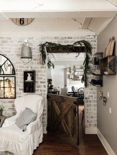 a white chair sitting in front of a mirror on a wall next to a wooden table