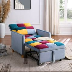 a multicolored chaise lounge chair sitting in a living room with a rug on the floor