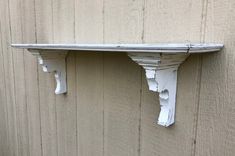 an old white shelf on the side of a building