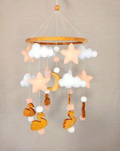 a baby crib mobile with ducks, stars and clouds