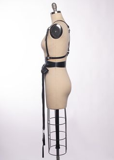 High quality, durable-yet-delicate bespoke harness made in leather or vegan leather. Embellished with tassels. Luxurious wide satin ribbons wrap around the waist and tie into a bow. Choose from gold or silver toned nickel plated steel hardware. Shown in black leather/gold ribbon/gold hardware and black leather/black ribbon/silver hardware. Custom sizing available. All pieces are MADE TO ORDER, standard sizes XS-4XL. If your measurements fall outside these standards or you are unsure of what size Gothic Leather Harness With Belt, Leather Strapped Harness With Belt, Leather Harness With Straps, Adjustable Belt Harness For Party, Black Leather Harness With Belt, Black Leather Harness With Belt Included, Fitted Leather Harness With Belt, Black Party Harness With Belt Loops, Party Harness With Belt Loops In Black