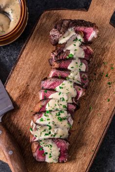 sliced steak with sauce and parsley on cutting board