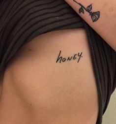 a woman with a tattoo on her shoulder that says honey