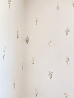 a white toilet sitting in a bathroom next to a wall with flowers painted on it