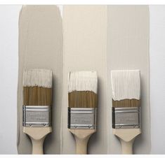 three paintbrushes with white and brown bristles on the side of each one