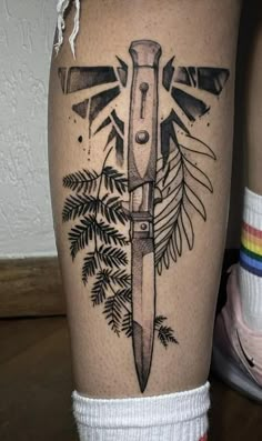 a tattoo on the leg of a person with a knife in it's center