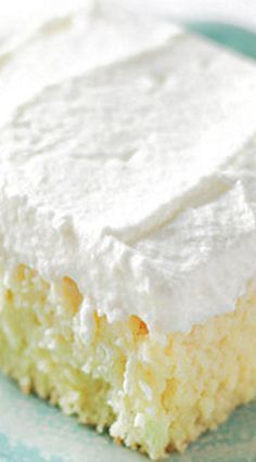 a close up of a piece of cake on a plate with whipped cream frosting