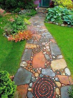 a walkway made out of rocks and stones in front of a house with green grass