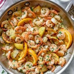 a pan filled with shrimp and potatoes on top of a table