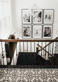 a staircase with pictures on the wall above it