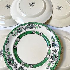 four plates with green and white designs on them