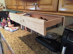 a kitchen counter with an open drawer on it