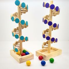 two wooden toys with different colored balls in them