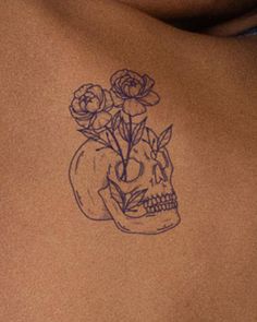 a woman's stomach with a skull and flowers on it