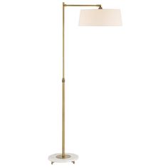 a floor lamp with a white shade on the base and a gold metal pole,