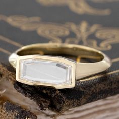 a close up of a gold ring with a white stone on it's side