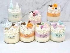 there are many small candles that have frosting in them and decorations on the top