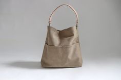 The best tote bags combine casual style with useful functionality in an easy to carry shape. Our canvas hobo bag gets it all just right.  Modern and minimalist with lots of pockets in all the right places.   Plenty of interior space with just the right amount of slouch so the bag never feels too big. Durably handcrafted with attention to detail in the perfect neutral khaki color that goes with everything. This listing is for the Large size as pictured.  More sizes and colors available in my Shop Versatile Beige Hobo Bag With Leather Handles, Versatile Hobo Shoulder Bag With Pockets, Neutral Hobo Shoulder Bag For Everyday, Neutral Everyday Hobo Shoulder Bag, Everyday Neutral Hobo Shoulder Bag, Modern Beige Hobo Bag For Everyday, Everyday Neutral Shoulder Hobo Bag, Everyday Canvas Bucket Bag With Removable Pouch, Canvas Hobo Bag With Pockets For Errands