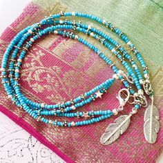 This turquoise beach anklet features a handmade silver feather charm and is intricately beaded with Indian style silver and turquoise glass seed beads. With dual strands and a little silver star added for good measure, this ankle bracelet has an adjustable chain allowing you to personalise the length to fit you perfectly. The strands can sit separately around your ankle or you can twist them together before you do up the clasp for a different look. Threaded onto tigers tail jewellery wire and held together with a slightly larger lobster clasp for ease of use, this turquoise beauty is wonderfully light to wear. Beautiful for a boho bride, day at the beach, casual or evening wear - this is an original myVardoJewellery design.  Your anklet will arrive in our signature beautiful and eco-friend Nickel-free Turquoise Beaded Bracelets For Festivals, Bohemian Silver Beads Anklets For Beach, Bohemian Silver Beaded Anklets For Beach, Turquoise Beaded Festival Anklets, Bohemian Turquoise Beaded Bracelets With Silver Beads, Bohemian Turquoise Beaded Bracelet With Silver Beads, Blue Beaded Bracelets With Silver Beads For Festivals, Turquoise Anklets With Tiny Beads For Festival, Turquoise Round Beads Anklet For Festivals