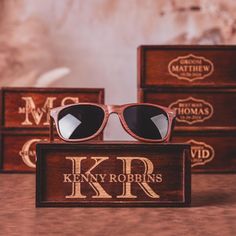 three wooden boxes with sunglasses on them sitting next to each other in front of the box