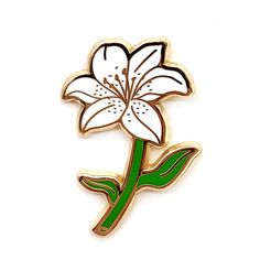 a white and green flower pin on a white background