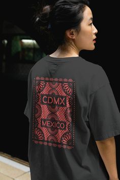 Welcome to our online T-shirt collection, where style meets culture! Introducing our vibrant and culturally rich CDMX Mexican Papel Picado T-shirt collection, inspired by the lively streets of Mexico City.   Celebrate the essence of Mexican tradition with our intricately designed Papel Picado T-shirts. Each shirt is a unique blend of contemporary fashion and traditional artistry, showcasing the intricate patterns and vibrant colors reminiscent of Mexican fiestas. Crafted with care and attention to detail, our T-shirts are made from premium quality materials, ensuring comfort and durability with every wear. Whether you're strolling through the bustling streets of CDMX or simply adding a touch of cultural flair to your wardrobe, our Mexican Papel Picado T-shirts are the perfect choice. Embra Festival Crew Neck T-shirt With Graphic Print, Festival Graphic Print Crew Neck T-shirt, Festival Graphic Print Crew Neck Top, Festival Graphic Crew Neck Top, Festival Crew Neck Top With Graphic Print, Graphic Print Crew Neck Top For Festival, Crew Neck Cotton Shirt For Festivals, Relaxed Fit Graphic Print Top For Festivals, Cotton Graphic T-shirt For Festivals