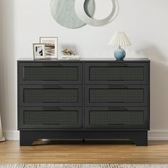 a black dresser sitting next to a wall with a clock on it's side