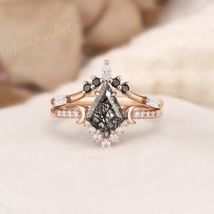 an engagement ring with black and white stones on it, set in rose gold plated setting