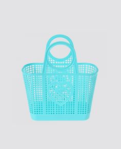 a blue plastic shopping basket with handles and an animal head on the front, against a white background