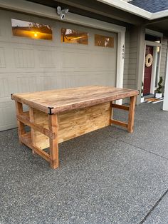 a large wooden table sitting in front of a garage door on top of a sidewalk