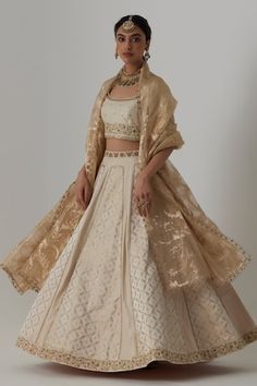 Off white panelled banarasi silk brocade, pure silk lehenga with bloom crest woven details and aari-zardozi embroidery highlights. Paired with a half sleeves floral bloom aari-zardozi embroidered blouse and floral woven banarasi brocade organza dupatta. - Aza Fashions Elegant Brocade Embroidered Fabric For Reception, Elegant Brocade Dupatta With Intricate Embroidery, Elegant Brocade Dupatta With Resham Embroidery, Elegant Cotton Silk Sets For Reception, Elegant Brocade Choli With Intricate Embroidery, Elegant Cotton Silk Choli, Elegant Brocade Sharara For Transitional Season, Elegant Transitional Brocade Sharara, Elegant Raw Silk Choli With Cutdana