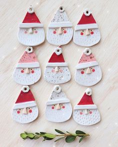 christmas ornaments with santa hats and eyeballs are arranged on a table next to greenery