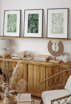 a living room with two framed pictures on the wall and a wicker sideboard