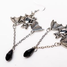 Unleash your inner darkness with these captivating Bat Earrings. Crafted from durable zinc alloy with a striking black finish, each earring measures 1.5 by 1 inch, featuring an elegant 1-inch chain adorned with a black diamond-shaped accent. Perfect for adding a touch of gothic charm to any outfit, these earrings are a must-have for your collection. Silver Alloy Earrings For Evening, Silver Alloy Drop Clip-on Earrings, Silver Alloy Crystal Earrings For Party, Silver Alloy Crystal Party Earrings, Nickel-free Alloy Earrings For Party, Dangle Crystal Alloy Earrings, Silver Alloy Jewelry For Evening, Punk Style Stainless Steel Party Jewelry, Punk Style Stainless Steel Jewelry For Party