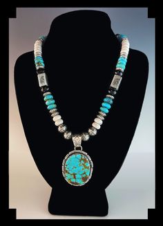 "For this White Fox Creation we started with a Pilot Mountain turquoise pendant. The pendant is set in a hand made scalloped sterling bezel accented with rolled and notched edge. Then we created a chain using chunky 10 mm turquoise, onyx and howlite rondelle beads, large Sterling Kokopelli stamped rectangular beads and large 10 mm Kokopelli stamped round beads.  Yes the pendant is easily removed so you can ware the chain alone.  Specifics: Metal: Sterling Silver  Stamped  Stones: Turquoise, Onyx Collectible Turquoise Jewelry With Large Stone, One-of-a-kind Oval Southwestern Jewelry, Artisan Medallion Jewelry With Natural Stones, Handmade Turquoise Medallion Necklace, Oval Turquoise Inlay Jewelry, Southwestern Jewelry With Large Round Pendant, Turquoise Round Pendant With Large Stone, Artisan Turquoise Oval Pendant Jewelry, Southwestern Style Oval Jewelry With Large Pendant