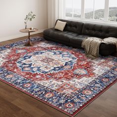 a living room with a couch and rug on the floor next to a large window