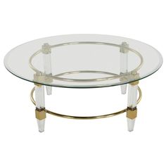 a glass and brass coffee table with wheels on the bottom, against a white background