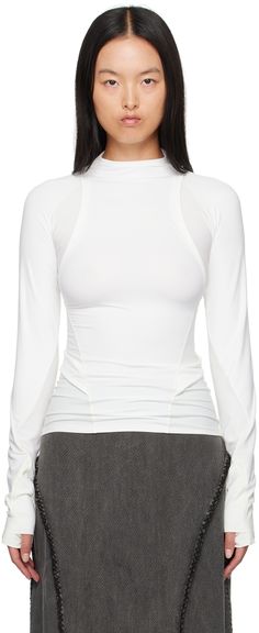 Stretch nylon jersey and ribbed jersey long sleeve T-shirt. · Paneled and layered construction · Mock neck · Logo-printed integrated straps at waist · Thumbhole at cuffs · Zip pockets at back Supplier color: White Sporty White Turtleneck Top, Sporty White High Neck Top, Sporty Turtleneck Top For Layering, Athleisure Turtleneck Tops For Layering, Fitted Turtleneck Athleisure Top, Hyein Seo, Jersey Long Sleeve, Active Wear For Women, Mock Neck