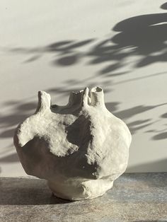 a white vase sitting on top of a cement slab