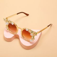 Gorgeous Flower Cat Eye Sunglasses inspired by Vintage European Fashion with a delicate floral design adorned with crystals. Style: Cat EyeDepartment Name: AdultFrame Material: RESINEyewear Type: SunglassesLens Height: 5.3CMLenses Material: Plastic Elegant Mirrored Sunglasses For Spring, Glamorous Gold Sunglasses For Summer, Feminine Tinted Sunglasses For Spring, Gold Glass Cat Eye Sunglasses For Party, Gold Cat Eye Sunglasses For Party, Gold Cat Eye Party Sunglasses With Glass Lenses, Elegant Glass Sunglasses For Summer, Elegant Gold Sunglasses For Spring, Elegant Gold Sunglasses