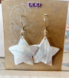 "These White Mother of Pearl Star Shaped Earrings will be the star of your earring show! They are lightweight and comfortable to wear as they dangle from your earlobes and light up your beautiful, happy face. Shiny & irridescent, these shell star earrings will make any outfit feel special.  Measures 1 3/4\" star tip to star tip. Silver Earwires" Star-shaped White Pearl Earrings For Gift, White Star-shaped Earrings With Star Charm, White Star Charm Earrings As Gift, White Star-shaped Nickel-free Earrings, White Star-shaped Earrings As Gift, Celestial Stars, White Star, Earrings White, Shell Earrings