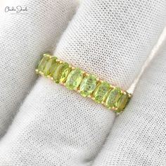 Description A peridot eternity band ring means never-ending love for your spouse. The shiny 5x3mm oval cut peridot gemstone encircles in an elegant eternity band that is defined in 14k solid gold and featuring a sharing prong setting. The warm goldenish-yellow peridot is a birthstone of august and, the quality of this pretty stone. This bright peridot eternity band ring is perfect as a wedding or birthday ring because of its everlasting shine. Product Details SKU CJ-R-1336-P-YG-NP Product dimens Peridot Band Ring, Luxury Peridot Three Stone Rings, Luxury Peridot Gemstone Ring, Peridot Promise Ring, Oval Peridot Gemstones For Anniversary, Green Oval Stackable Rings, Peridot Wedding Band, Peridot Ring Gold, Peridot Rings