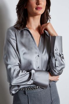 Nothing beats the chic factor and luxe patina of a Silk Satin shirt. Our button-down design features a v-neckline that is perfect for layering under a blazer or wearing on its own- you will live in this shirt all season long. Elie Tahari Exclusive Long Sleeve Silk Satin Button Down shirt 100% Silk Relaxed Fit; Runs true to size. Model is 5'9" and wearing size S Length From Shoulder to Hem: Back 26"L, Sleeve 32.5"L (approx. length for size S) Dry Clean Only Imported Style #: E807G524 Elegant V-neck Top With Button Cuffs, Fitted V-neck Shirt With Button Cuffs, Formal V-neck Shirt With Button Closure, Sleek Spread Collar Blouse For Fall, Formal V-neck Shirt With Buttons, Chic Business Casual Blouse With Lapel Collar, Sleek Blouse With Spread Collar For Fall, Chic Shirt With Hidden Button Closure For Fall, Chic Fall Shirt With Hidden Button Closure