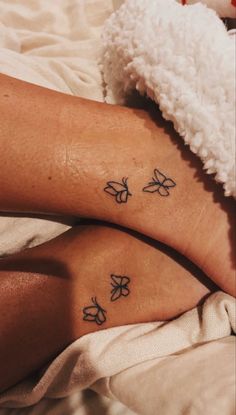 two women's legs with butterfly tattoos on them