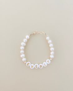 Beautiful pearl name bracelet ❤️A Single bracelet and a custom word of your choosing. These 14k gold filled beaded bracelets are made from high-quality, durable tarnish resistant beads and gold findings This Pearl bracelet is the perfect and affordable accessory for any little sweetie. Purchase multiples to layer them on! These make GREAT baby photo prop accessories. Can be used as an Ankle Bracelet. Customizable worded bracelet stacks. Perfect for birthdays, gender reveals, baby announcements, Personalized Yellow Gold Jewelry With Round Beads, Personalized Yellow Gold Beaded Bracelets With Round Beads, Personalized Yellow Gold Beaded Bracelets, Personalized Gold Name Bracelet With Round Beads, Classic Letter Beads Jewelry As Gift, Classic Letter Beads Jewelry Gift, Dainty Beaded Name Bracelet For Everyday, Classic White Bracelets For Mother's Day, Everyday Yellow Gold Personalized Bracelets